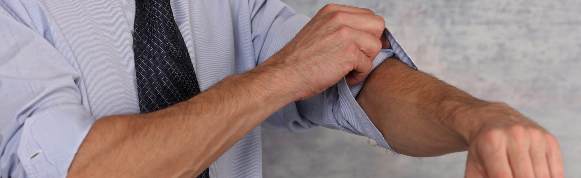 Businessman Rolling Up Sleeves.
